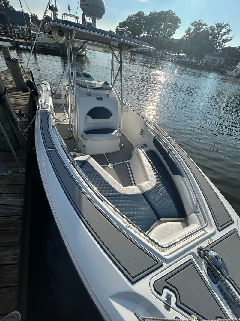 Slide: The Image of A 2004 Boston Whaler 270 Outrage docked. It features a spacious deck and blue upholstery. - 4