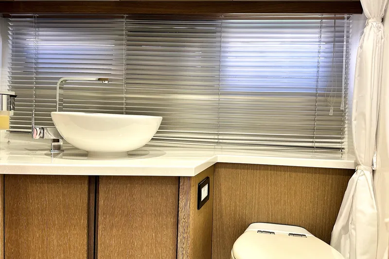 Slide: The Image of Modern bathroom interior on 2019 Galeon 485 HTS yacht, featuring sleek sink and blinds. - 30