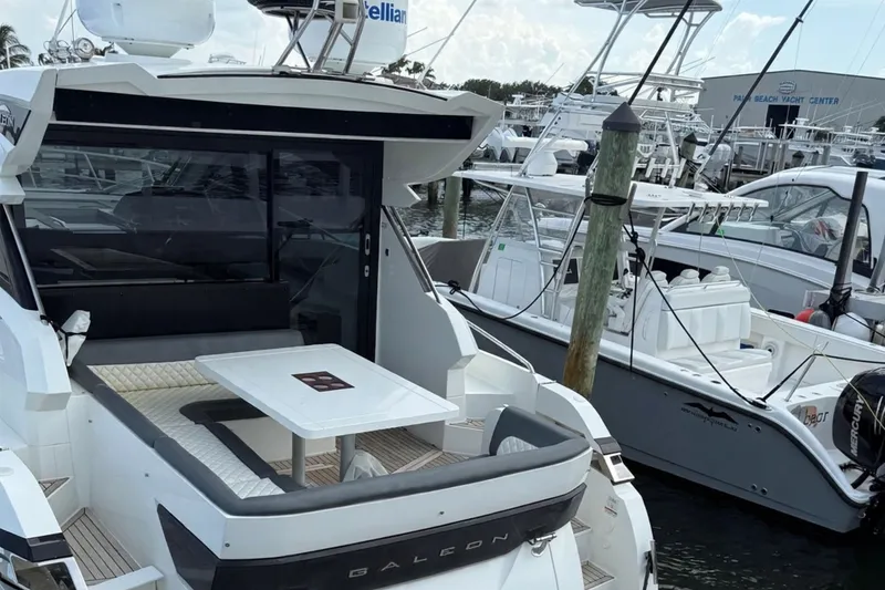 Slide: The Image of 2019 Galeon 485 HTS yacht docked at marina, featuring outdoor seating area. - 2
