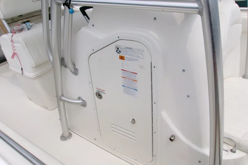 Slide: The Image of 2010 Robalo R240 Center Console boat interior with storage compartment and safety labels. - 34