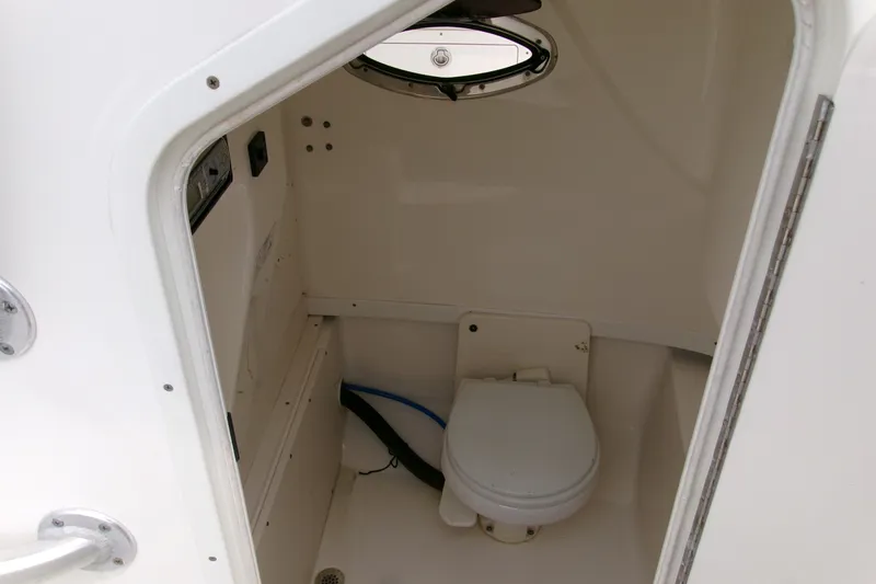 Slide: The Image of Interior view of 2010 Robalo R240 Center Console boat's compact marine toilet. - 35