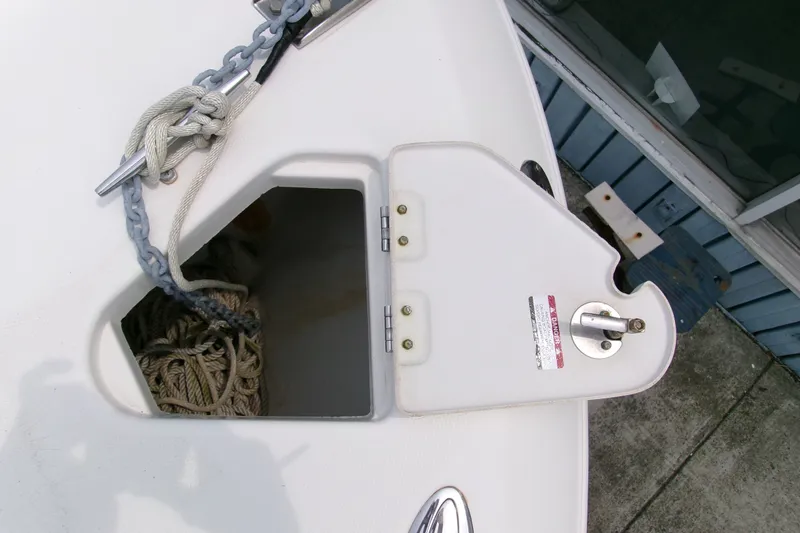 Slide: The Image of Anchor storage compartment on a 2010 Robalo R240 Center Console boat, featuring ropes and chains. - 47