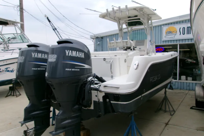 Slide: The Image of 2010 Robalo R240 Center Console boat with twin Yamaha 150 engines displayed outdoors. - 52