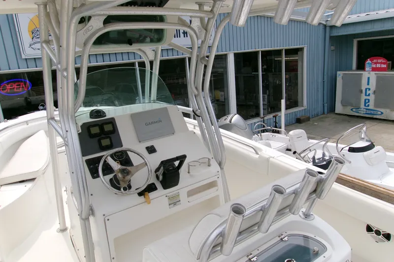 Slide: The Image of 2010 Robalo R240 Center Console boat with Garmin navigation, docked near a blue building. - 3