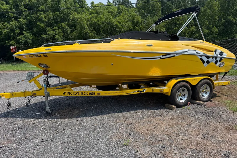 The Image of Yellow 2007 Crownline 21 SS boat on trailer, parked outdoors. - 2
