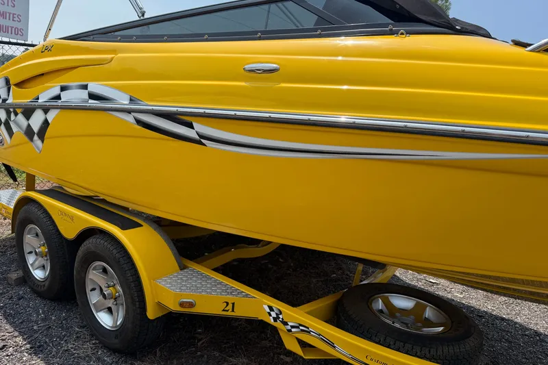 Slide: The Image of Yellow 2007 Crownline 21 SS boat with checkered flag design on trailer. - 5
