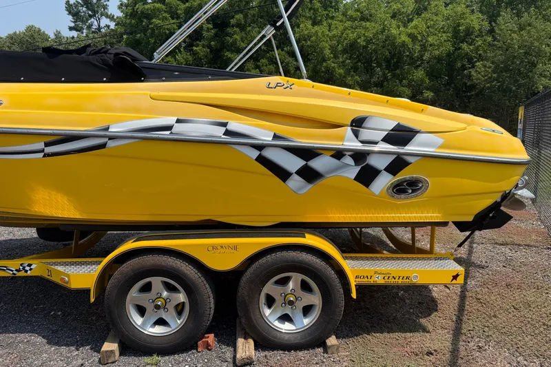 Slide: The Image of Yellow 2007 Crownline 21 SS boat with checkered flag design on trailer. - 3