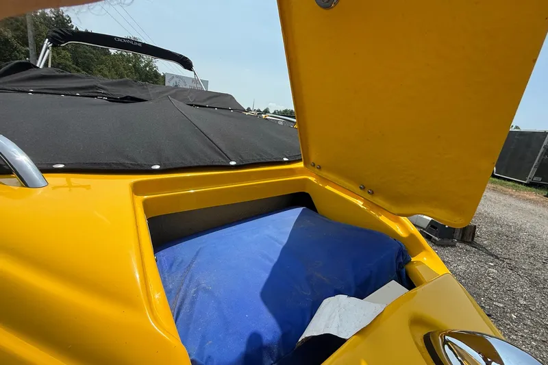 Slide: The Image of Yellow 2007 Crownline 21 SS boat with open storage compartment and black cover. - 17