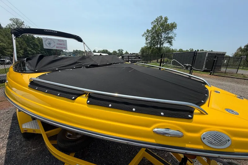 Slide: The Image of Yellow 2007 Crownline 21 SS boat with black cover, parked outdoors. - 15