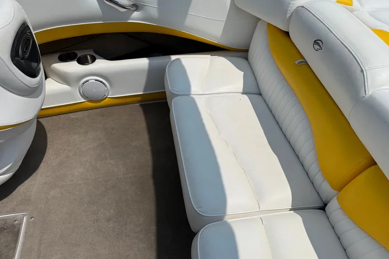 Slide: The Image of 2007 Crownline 21 SS boat interior with white and yellow seating, speaker, and cup holders. - 22