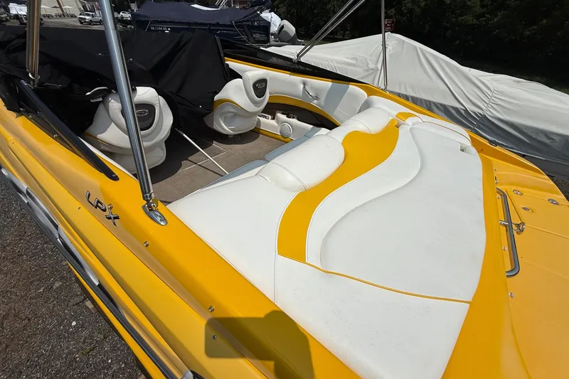 Slide: The Image of 2007 Crownline 21 SS boat with yellow and white seating, parked outdoors. - 19