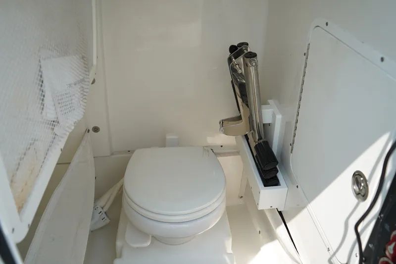 Slide: The Image of Interior of 2022 Sea Hunt Gamefish 25 boat featuring a compact marine toilet. - 22