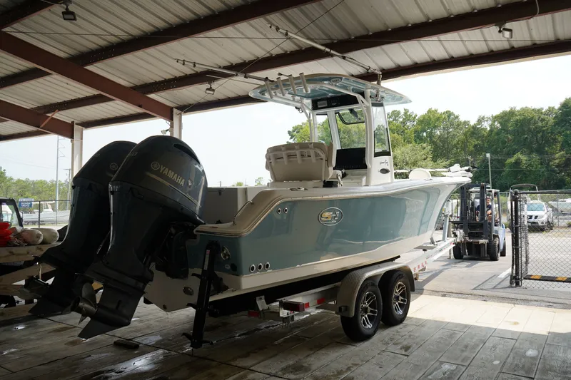Slide: The Image of 2022 Sea Hunt Gamefish 25 boat with dual Yamaha engines on a trailer in a covered area. - 15