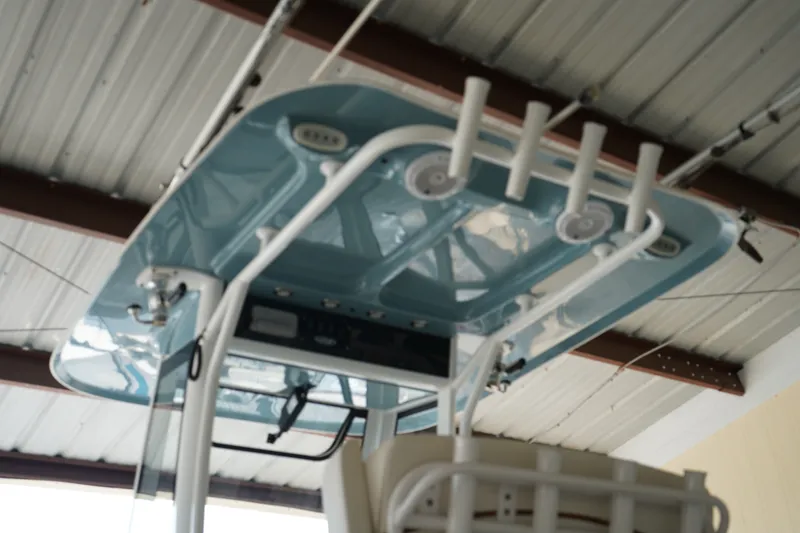 Slide: The Image of 2022 Sea Hunt Gamefish 25 boat with blue hardtop and rod holders in a garage. - 19