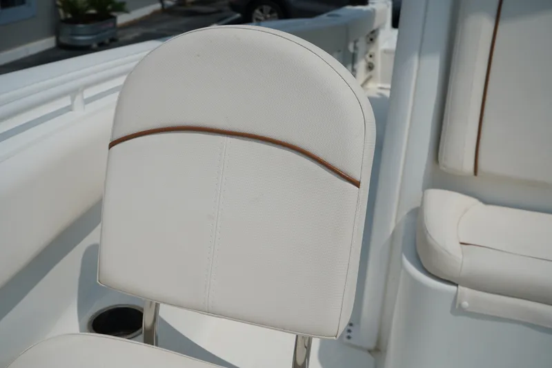 Slide: The Image of 2022 Sea Hunt Gamefish 25 boat seat with white upholstery and brown accent. - 5