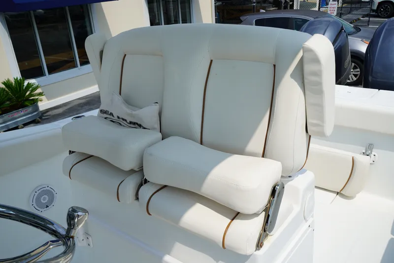 Slide: The Image of 2022 Sea Hunt Gamefish 25 boat seat with white upholstery and brown accents. - 8