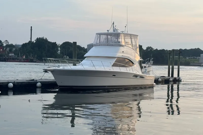Slide: The Image of 2009 Riviera 45 Open Flybridge yacht docked on calm water at sunset. - 1