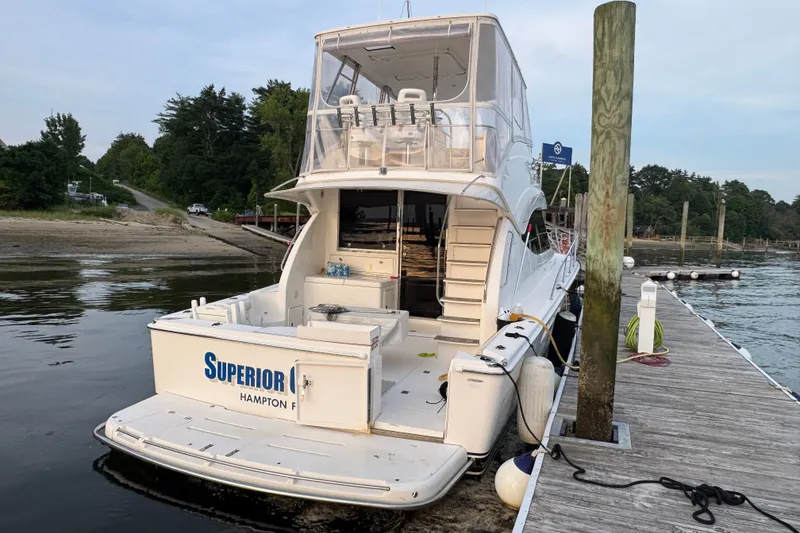 Slide: The Image of 2009 Riviera 45 Open Flybridge yacht docked at a serene marina. - 5