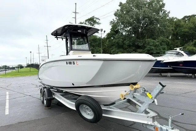 Slide: The Image of 2024 Yamaha Boats 255 FSH Sport H on trailer, parked outdoors, showcasing sleek design. - 1