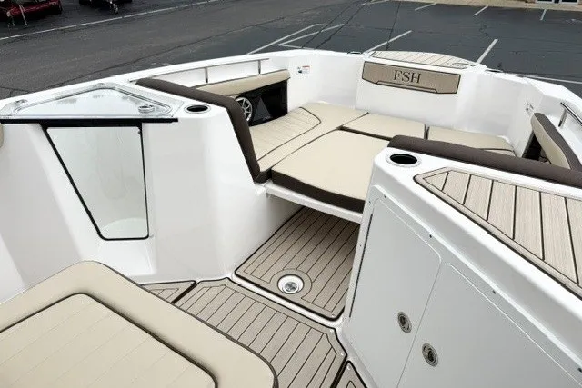 Slide: The Image of 2024 Yamaha Boats 255 FSH Sport H interior with beige seating and sleek design. - 13