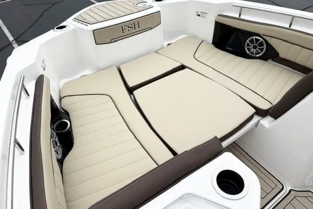 Slide: The Image of 2024 Yamaha Boats 255 FSH Sport H interior with beige seating and cup holders. - 10