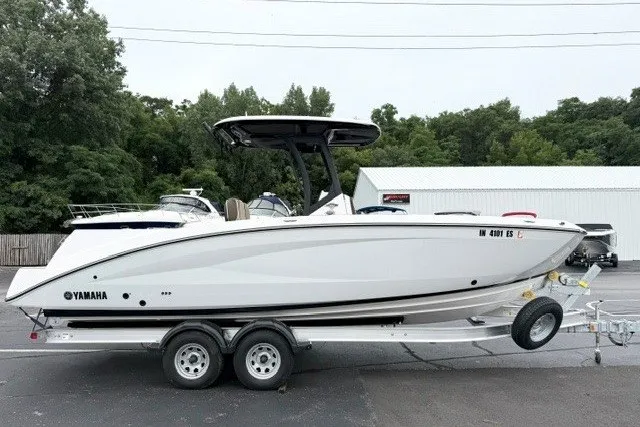 Slide: The Image of 2024 Yamaha Boats 255 FSH Sport H on trailer, parked outdoors. - 2
