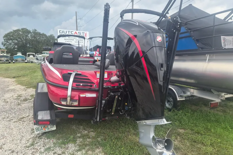 Slide: The Image of Red 2021 Nitro Z20 boat with powerful outboard motor, parked on grassy lot. - 4