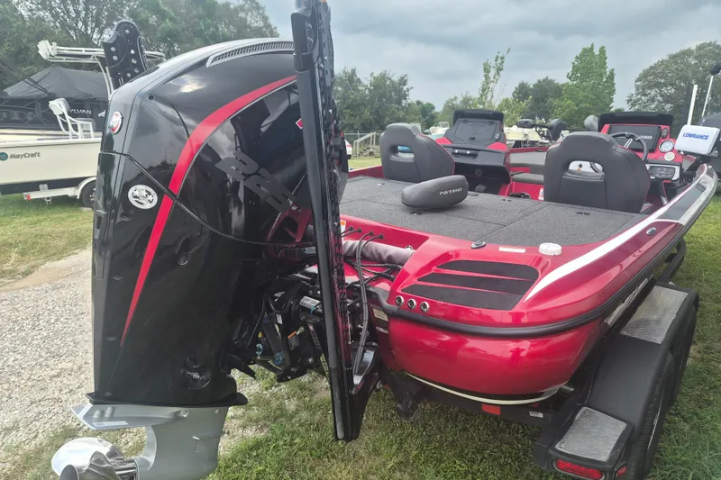 Slide: The Image of Red 2021 Nitro Z20 boat with powerful outboard motor, parked on grass. - 5