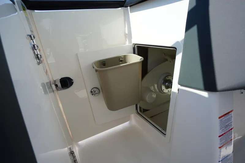 Slide: The Image of Interior storage compartment of 2026 Chaparral 270 OSX boat with trash bin. - 34
