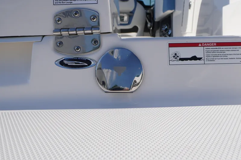 Slide: The Image of 2026 Chaparral 270 OSX boat detail with chrome fittings and safety warning label. - 77