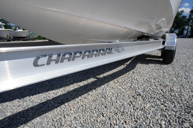 Slide: The Image of 2026 Chaparral 270 OSX boat trailer on gravel, showcasing brand logo. - 84