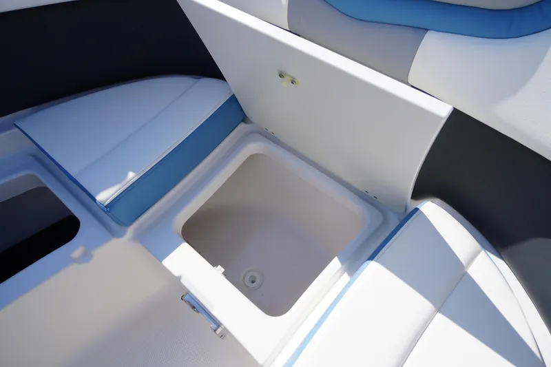 Slide: The Image of 2026 Chaparral 270 OSX boat interior storage compartment with blue and white seating. - 13
