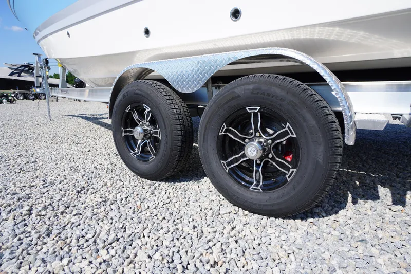 Slide: The Image of Trailer wheels of a 2026 Chaparral 270 OSX boat on gravel surface. - 86