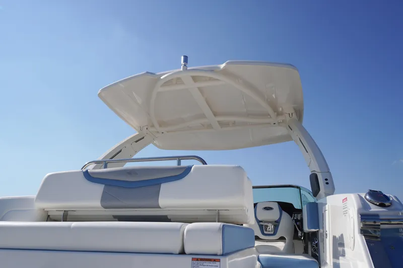 Slide: The Image of 2026 Chaparral 270 OSX boat with sleek seating and canopy under clear blue sky. - 70