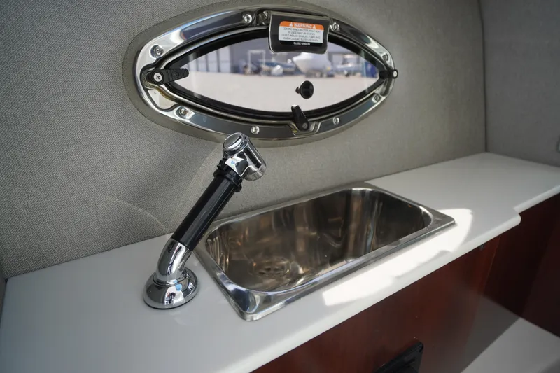 Slide: The Image of 2026 Chaparral 270 OSX boat interior with sink and porthole window. - 31