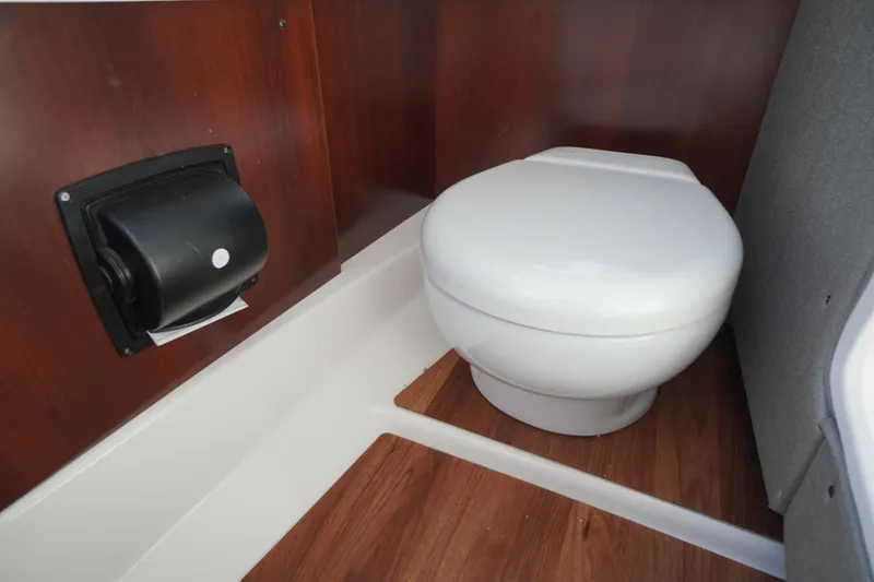 Slide: The Image of 2026 Chaparral 270 OSX boat interior with modern toilet and wood paneling. - 33