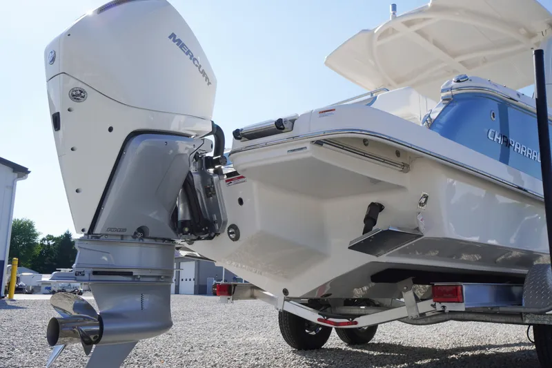 Slide: The Image of 2026 Chaparral 270 OSX boat with Mercury outboard engine, parked on gravel. - 78