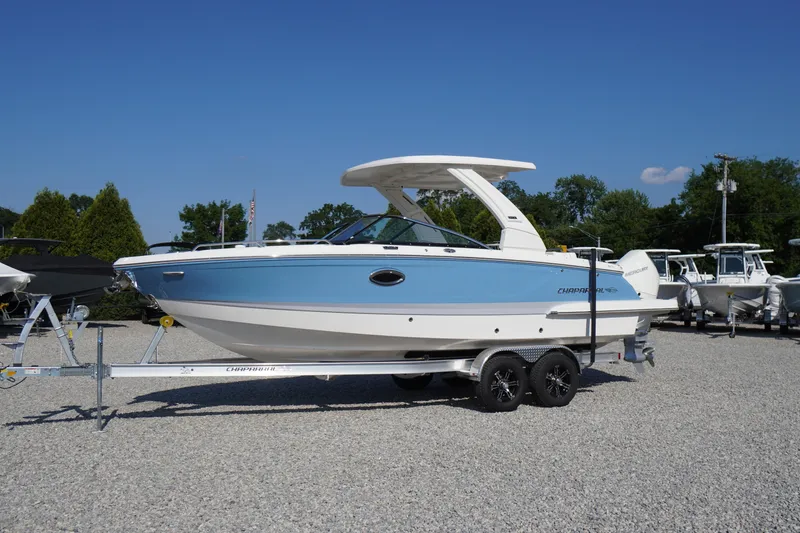 The Image of 2026 Chaparral 270 OSX boat on trailer, blue and white design, parked outdoors. - 0