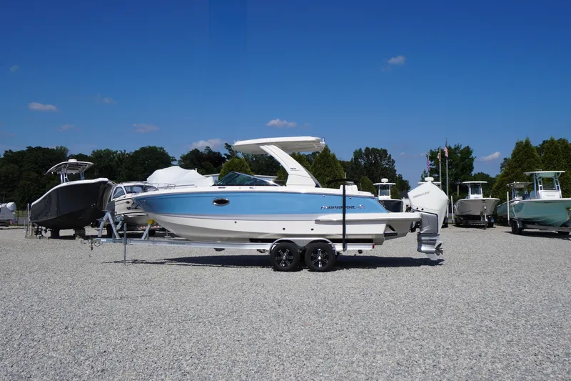 Slide: The Image of 2026 Chaparral 270 OSX boat on trailer, displayed outdoors under clear blue sky. - 2
