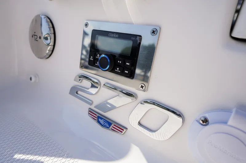 Slide: The Image of 2026 Chaparral 270 OSX boat dashboard with Clarion audio system and model emblem. - 59