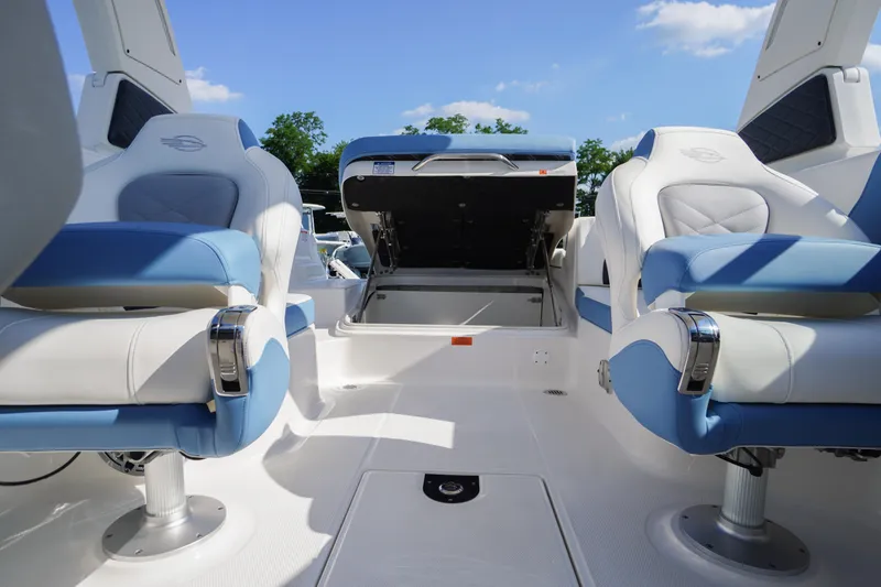 Slide: The Image of 2026 Chaparral 270 OSX boat interior with blue and white seating, open storage compartment. - 46