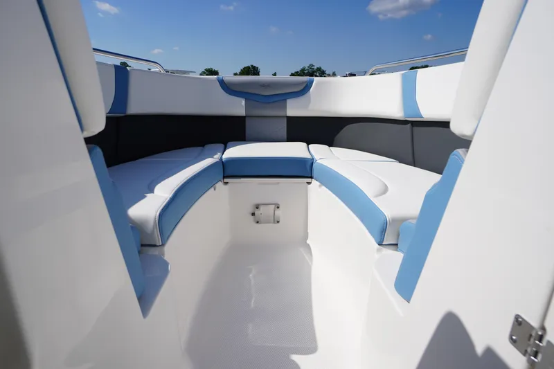Slide: The Image of 2026 Chaparral 270 OSX boat interior with blue and white seating under a clear sky. - 9