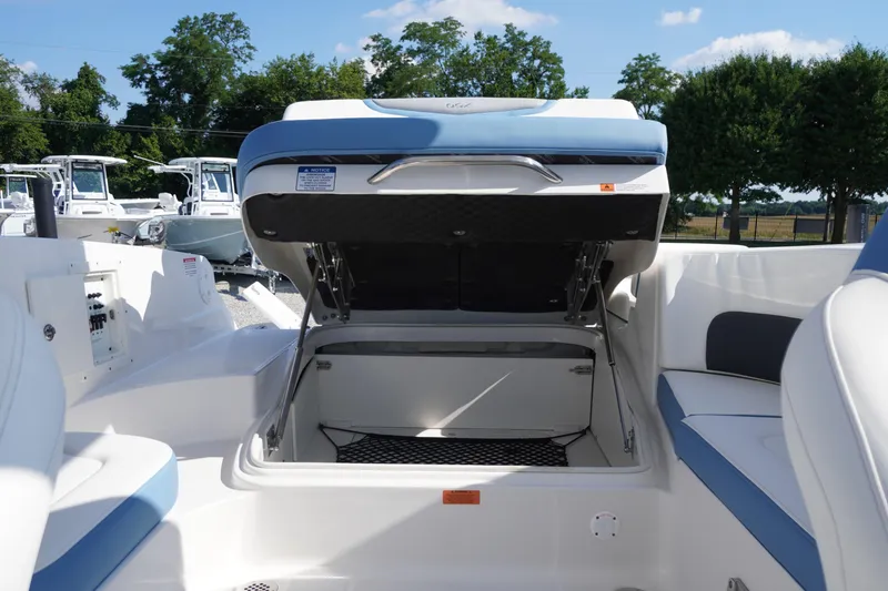Slide: The Image of 2026 Chaparral 270 OSX boat interior with open storage compartment, showcasing seating and controls. - 50