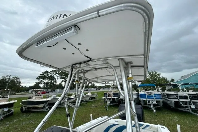 Slide: The Image of 1999 Donzi boat with T-top canopy, parked among other boats under cloudy skies. - 40