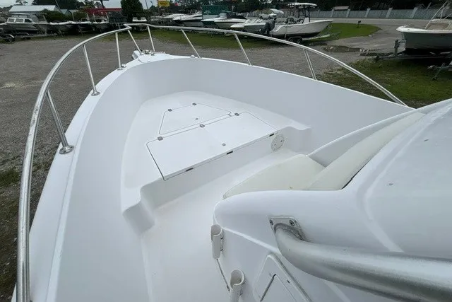 Slide: The Image of 1999 Donzi boat deck with white seating and railing in a marina setting. - 17