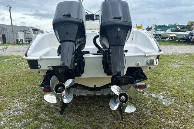 Slide: The Image of Twin outboard motors on a 1999 Donzi boat, parked on grass. - 11