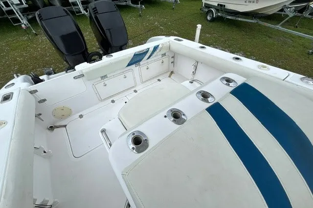 Slide: The Image of 1999 Donzi boat interior with white and blue seating, rod holders, and dual outboard motors. - 32