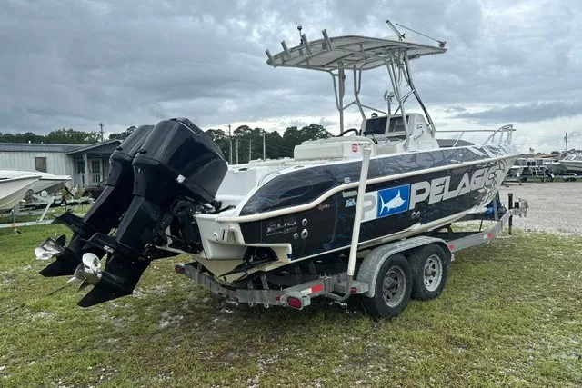 Slide: The Image of 1999 Donzi boat on trailer with dual engines, featuring Pelagic branding, under cloudy skies. - 2
