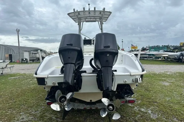 Slide: The Image of 1999 Donzi boat with dual outboard motors, parked on grassy area under cloudy sky. - 3