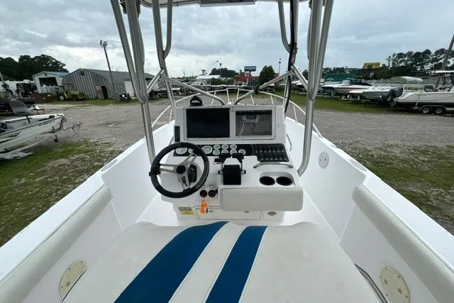 Slide: The Image of 1999 Donzi boat cockpit with steering wheel, control panel, and seating in a marina setting. - 15